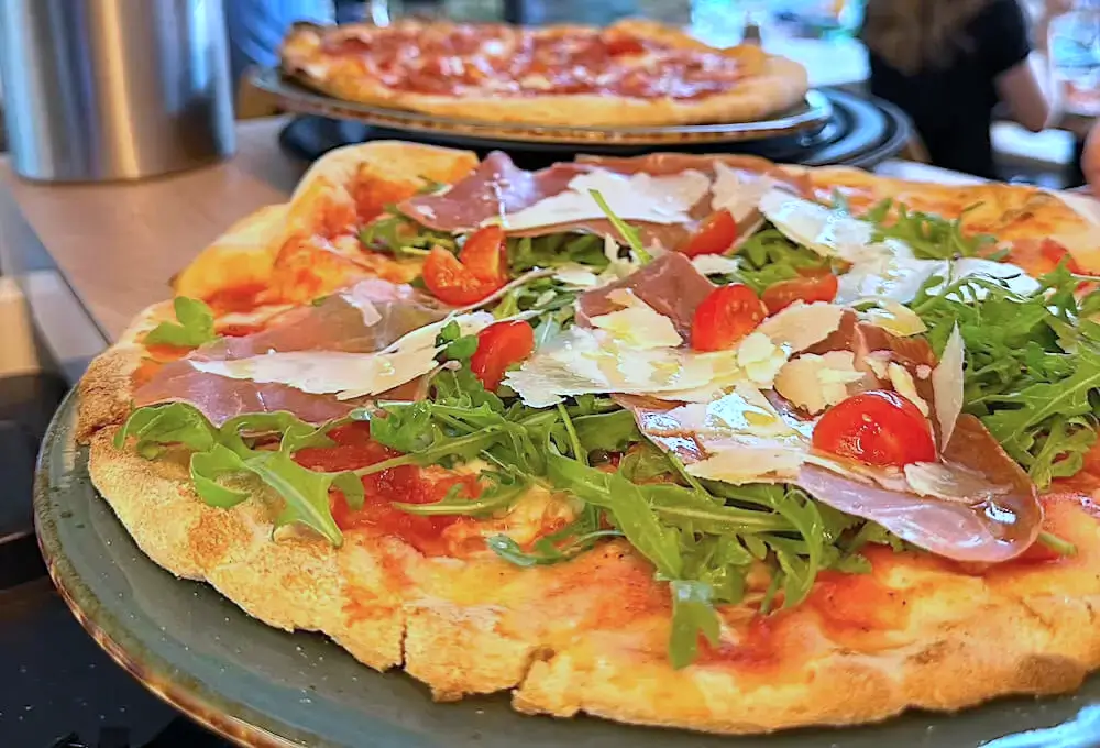Glutenfreie Pizza mit Prosciutto, Rucola und Parmesan aus dem Restaurant Mixto Verde im Glockenbachviertel München